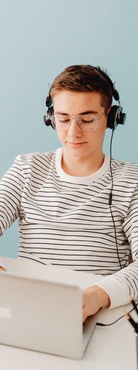 Estudiante con auriculares practicando inglés en su laptop