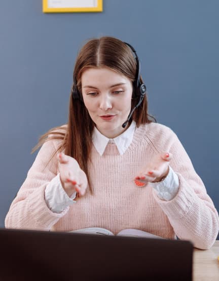 Profesional practicando inglés con auriculares frente a su laptop