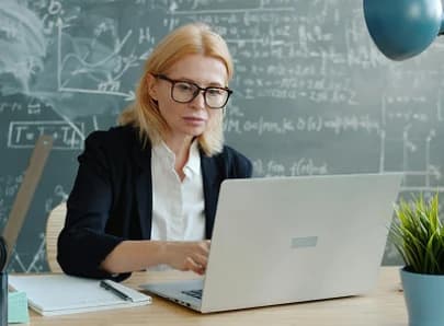 Profesora dando orientación personalizada desde su laptop
