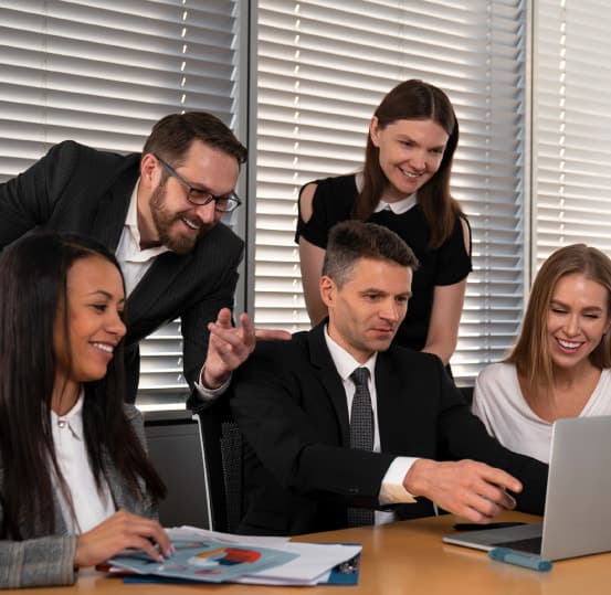 Equipo de profesionales reunido para trabajar en una laptop